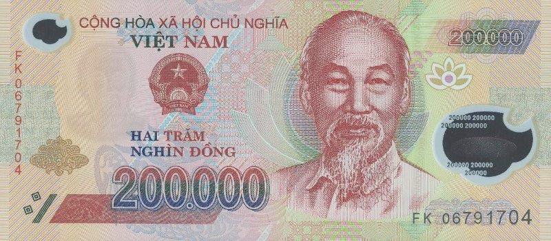 Obverse of the 200,000 đồng Vietnamese polymer banknote: engraved portrait of Hồ Chí Minh, State Emblem of Vietnam, denomination "200.000" and the legend "HAI TRĂM NGHÌN ĐỒNG" on a red-pink polymer ground, with a clear transparent window at the right (serial FK 06791704)
