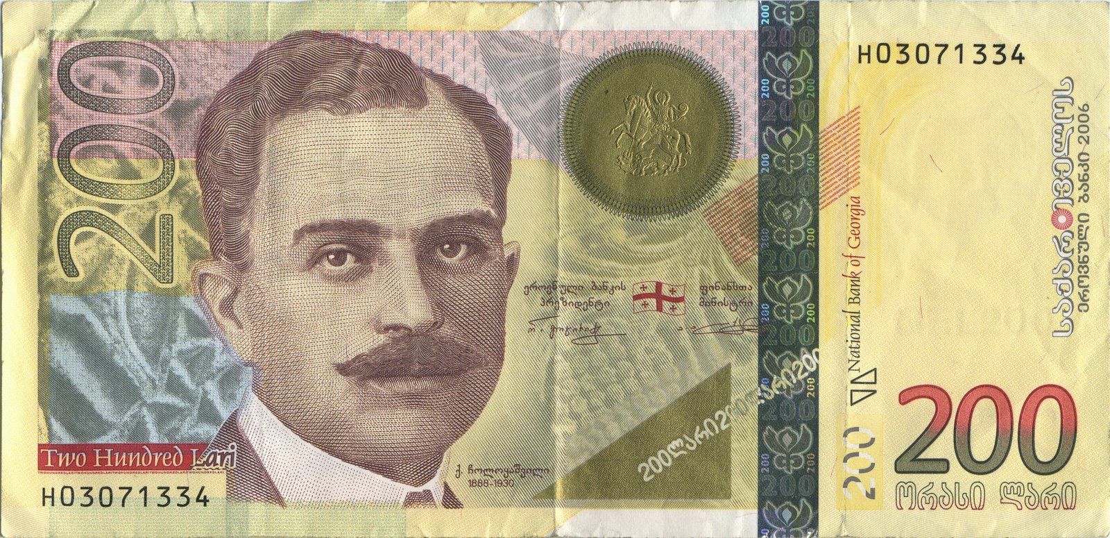 Obverse of the 200-lari Georgian banknote, showing a sepia engraved portrait of Kakutsa Cholokashvili in 1920s suit with moustache, the Georgian flag and a circular gold Coat of Arms of Georgia with Saint George above his shoulder, his signature, and "200" denomination markers on a yellow and pink ground; the figure carries the inscription "კ. ჭოლოყაშვილი 1888–1930"