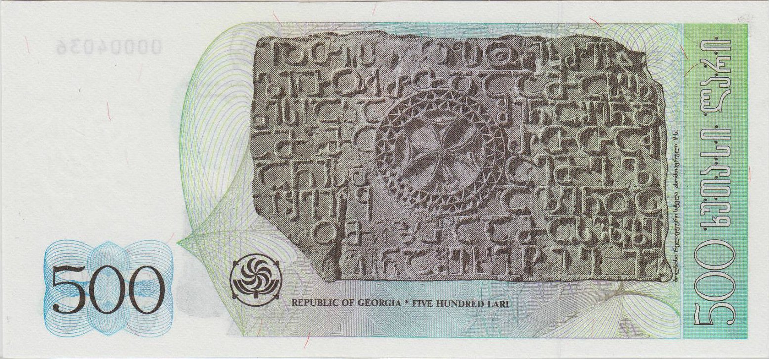 Reverse of the unissued 500-lari Georgian banknote dated 1995, showing a large carved stone slab from the Bolnisi Sioni basilica with a central Bolnisi Cross medallion and surrounding Georgian asomtavruli inscriptions, against a pale green ground, with the denomination 500 at both lower corners and the legend "REPUBLIC OF GEORGIA · FIVE HUNDRED LARI" beneath